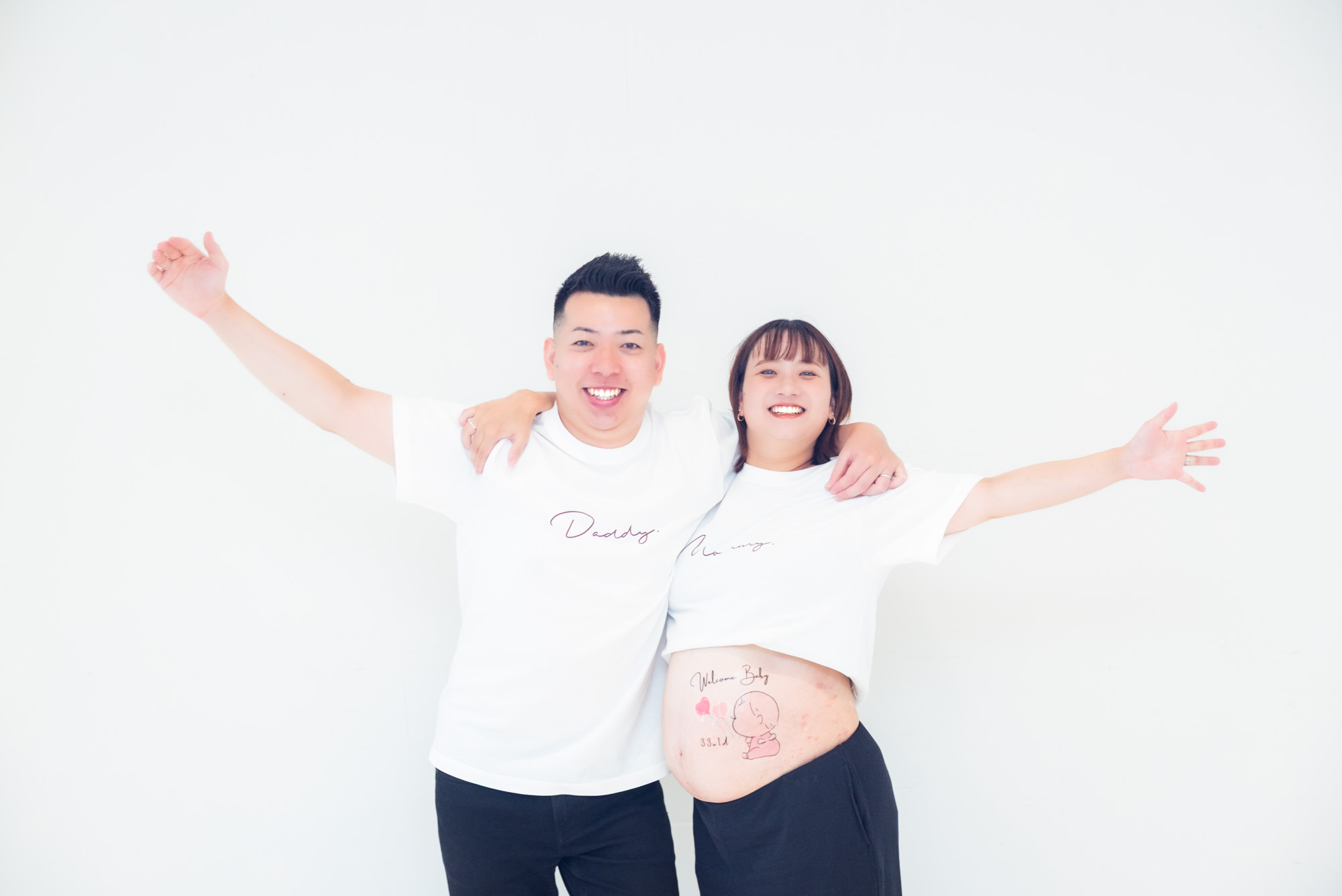 パパとママが両手を広げて笑っている写真